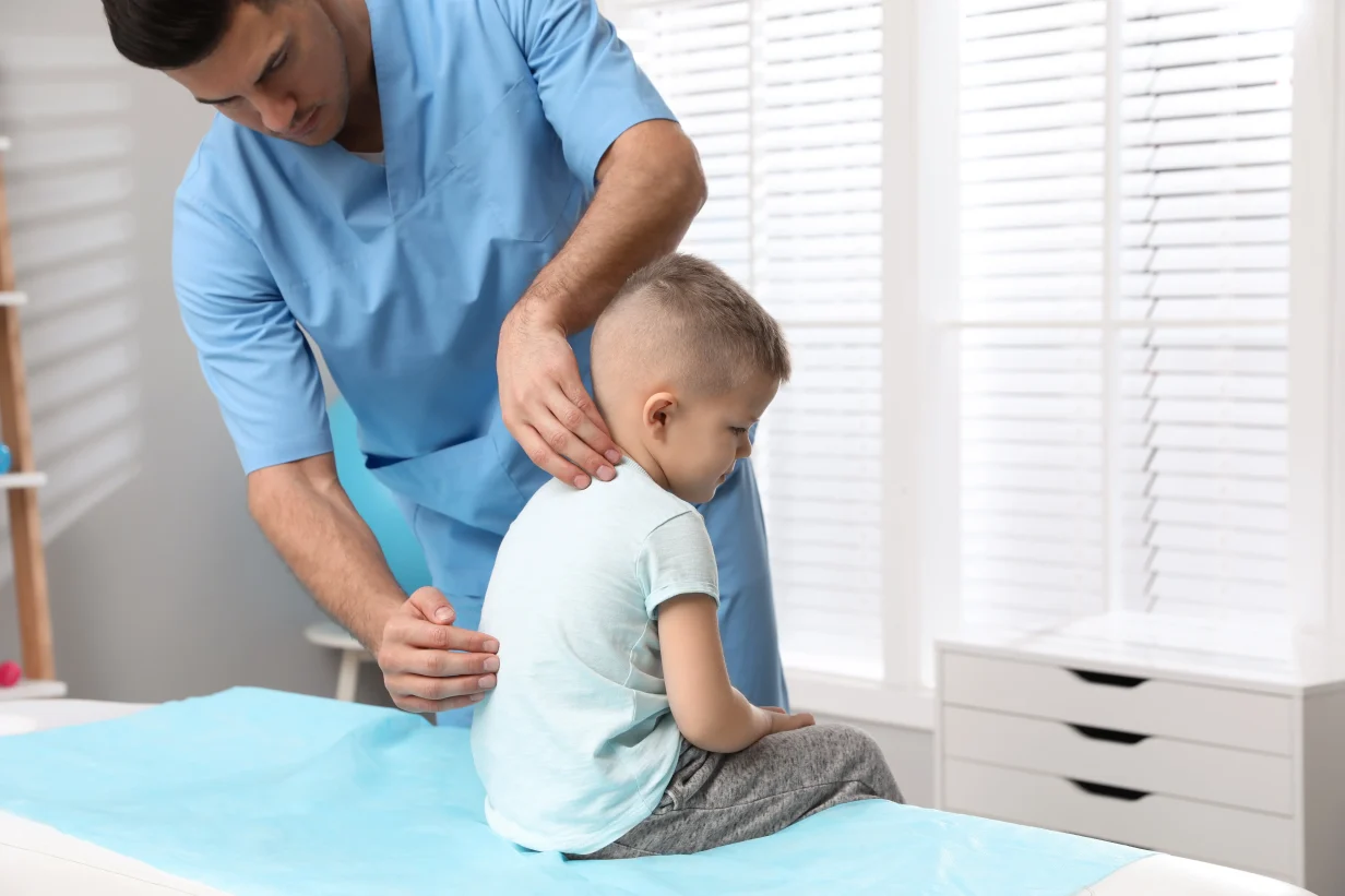 Medico valuta postura di un paziente bambino