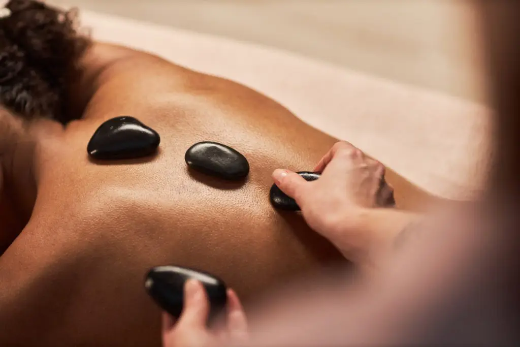 Massaggiatore che massaggia con delle pietre