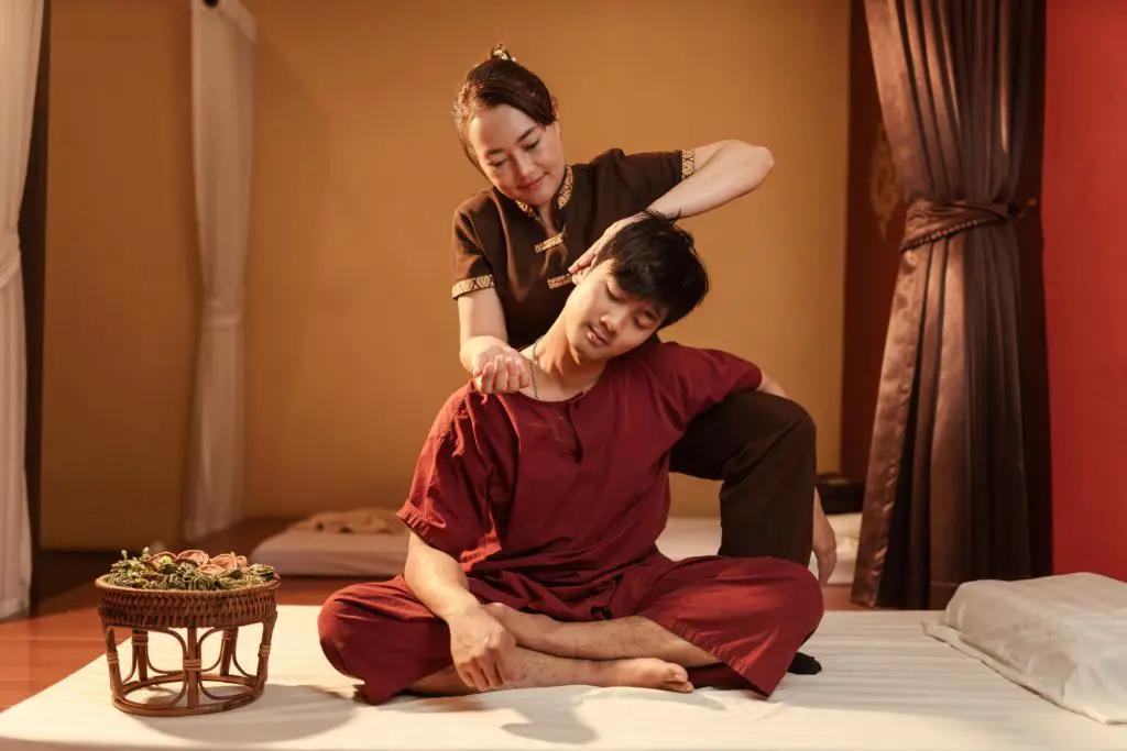 Massaggiatore che pratica massaggio thailandese